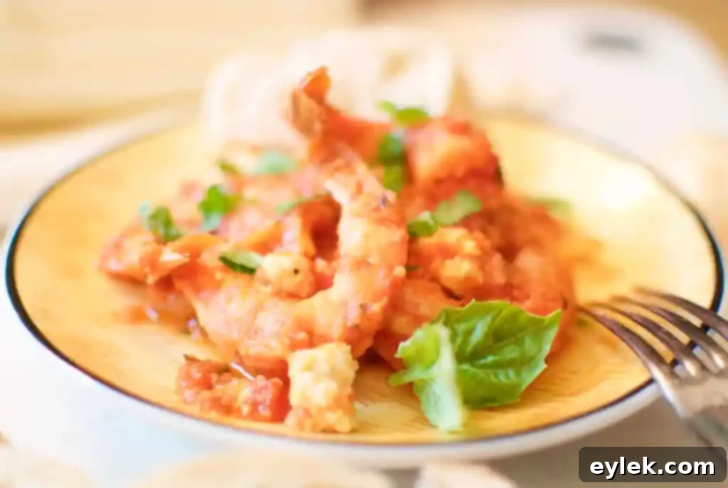 Top-down view of a skillet of roasted shrimp with fennel and feta, garnished