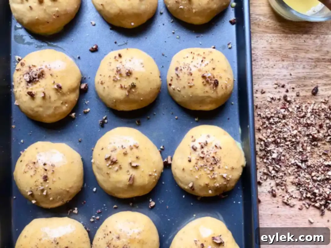 pumpkin rolls topped with pecans, ready for oven