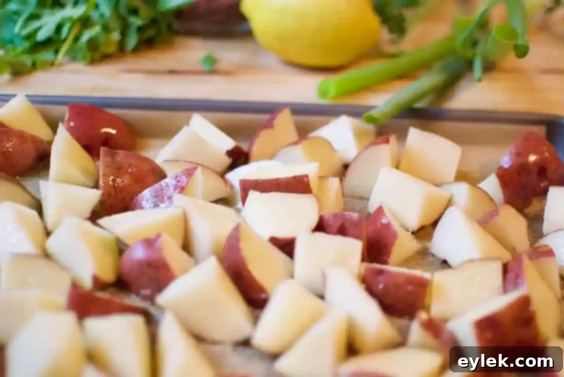 Roasted red-skinned potatoes with olive oil, salt, and pepper on a baking sheet