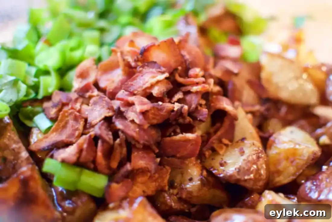 Balsamic Roasted Potato Salad with bacon, scallions, and arugula in a serving bowl
