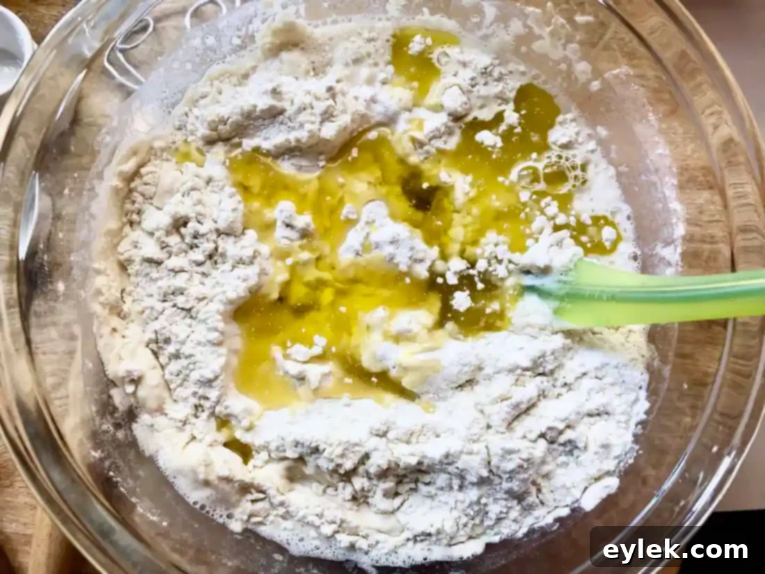 Dough covered with plastic wrap, rising in a bowl