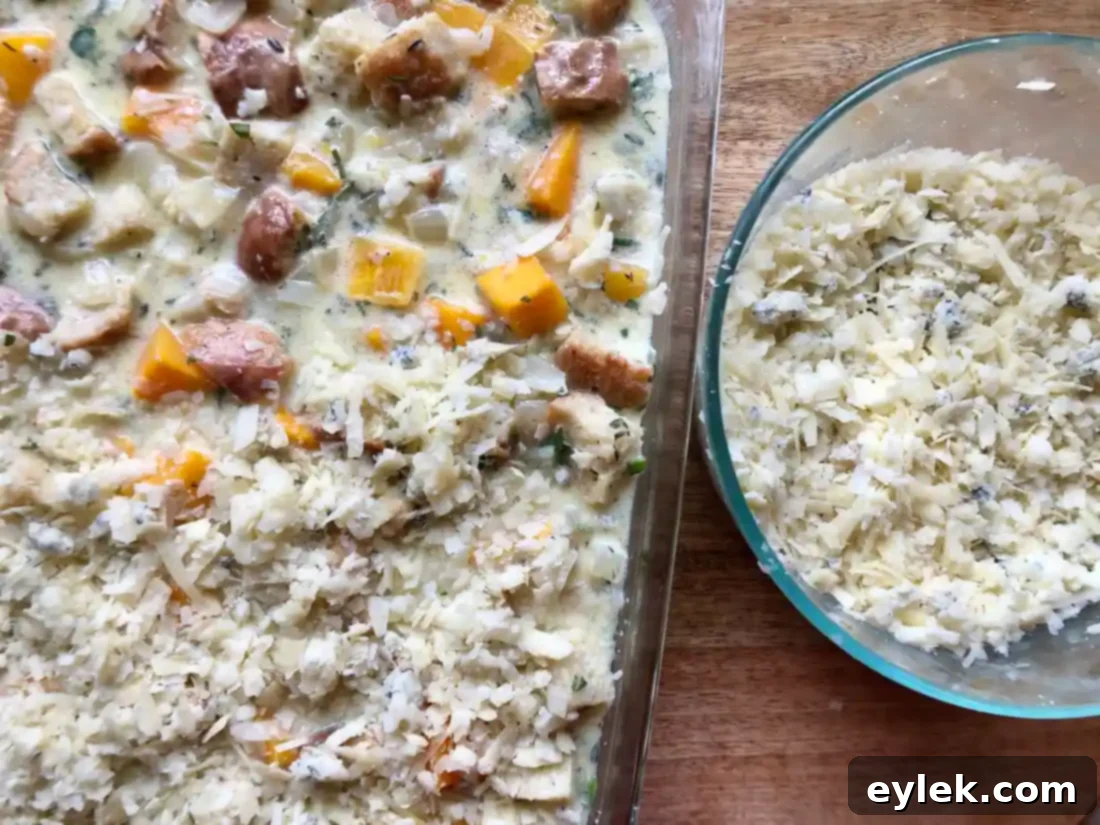 butternut squash bread pudding mixture in a baking dish topped with cheese