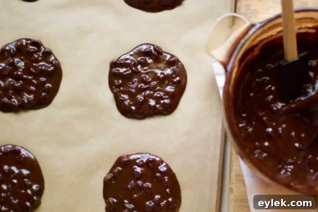 Parchment-lined baking sheet with flattened cookie dough
