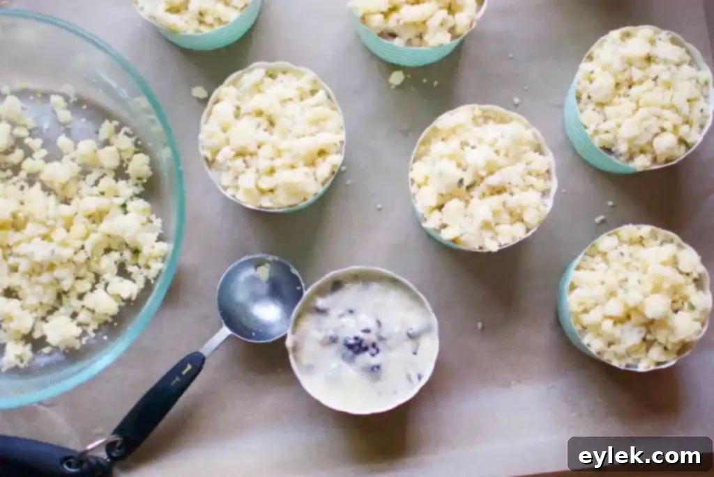 Muffin molds filled with batter, ready for crumble topping