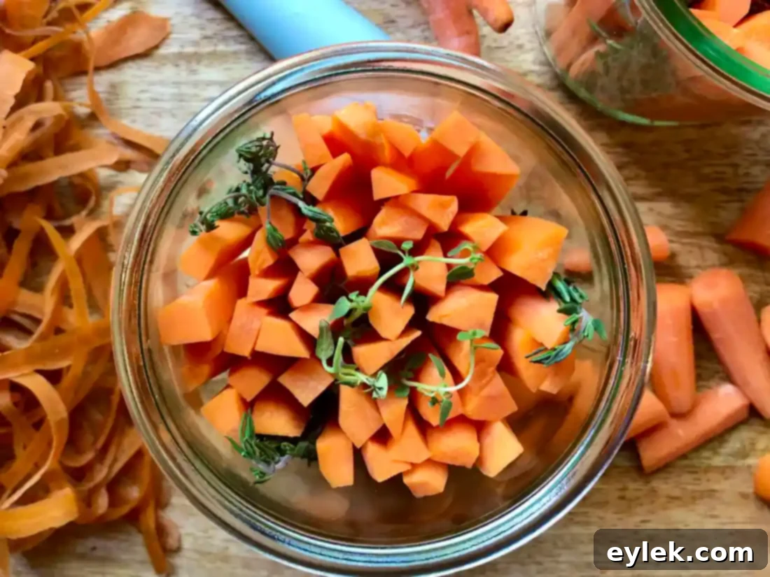 Hand placing carrot spears into a pickling jar