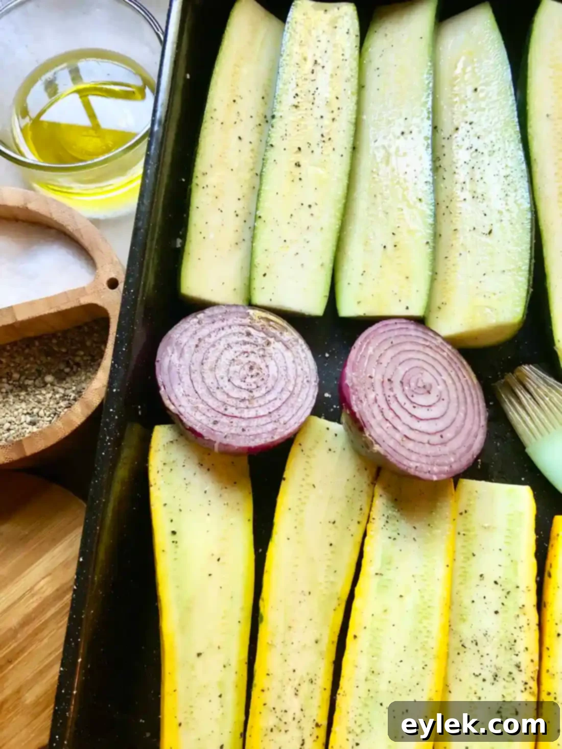 Freshly grilled zucchini, yellow squash, and red onion cooling on a plate