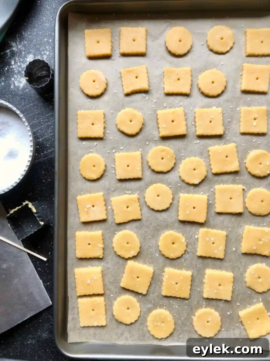 Cheese cracker shapes with holes poked, ready for baking
