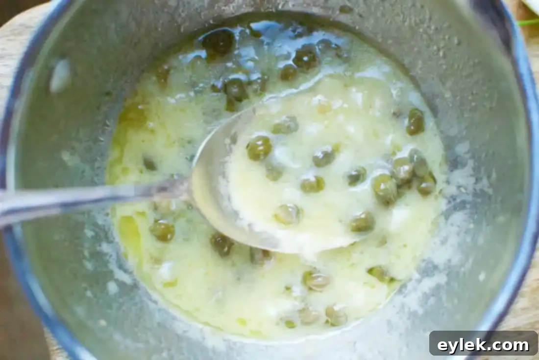 Finished butter lemon caper sauce in a saucepan
