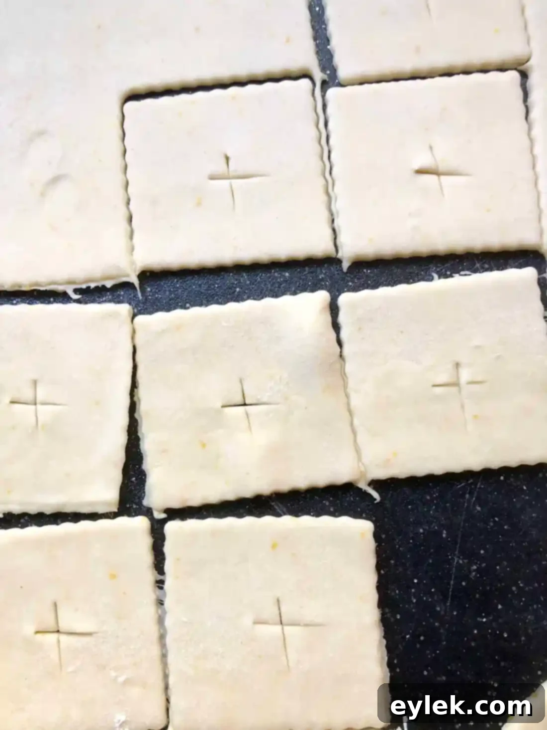 Dough squares cut for hand pies, some with vents for the top layer
