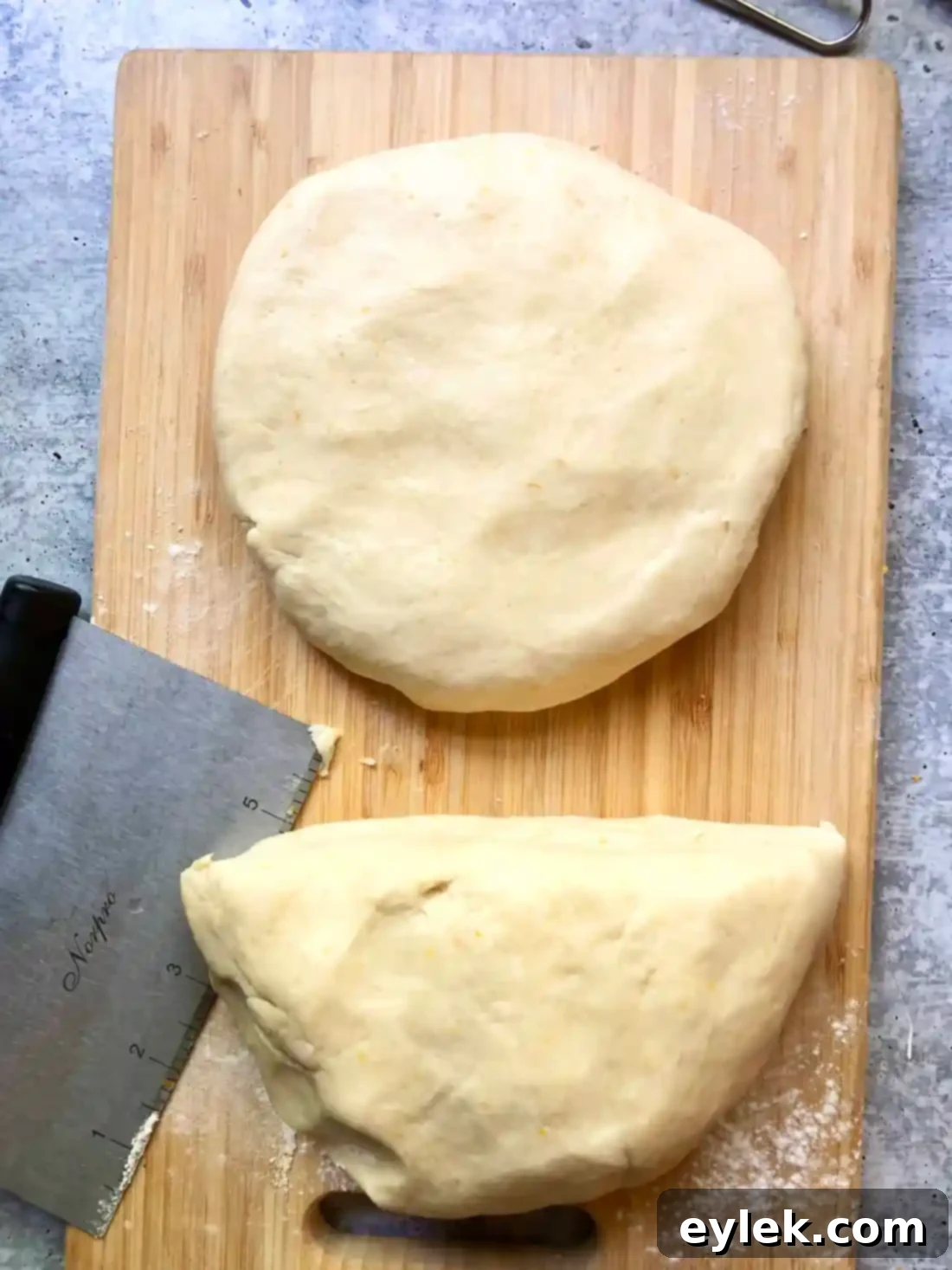 Two discs of pie dough wrapped in plastic wrap, ready for chilling