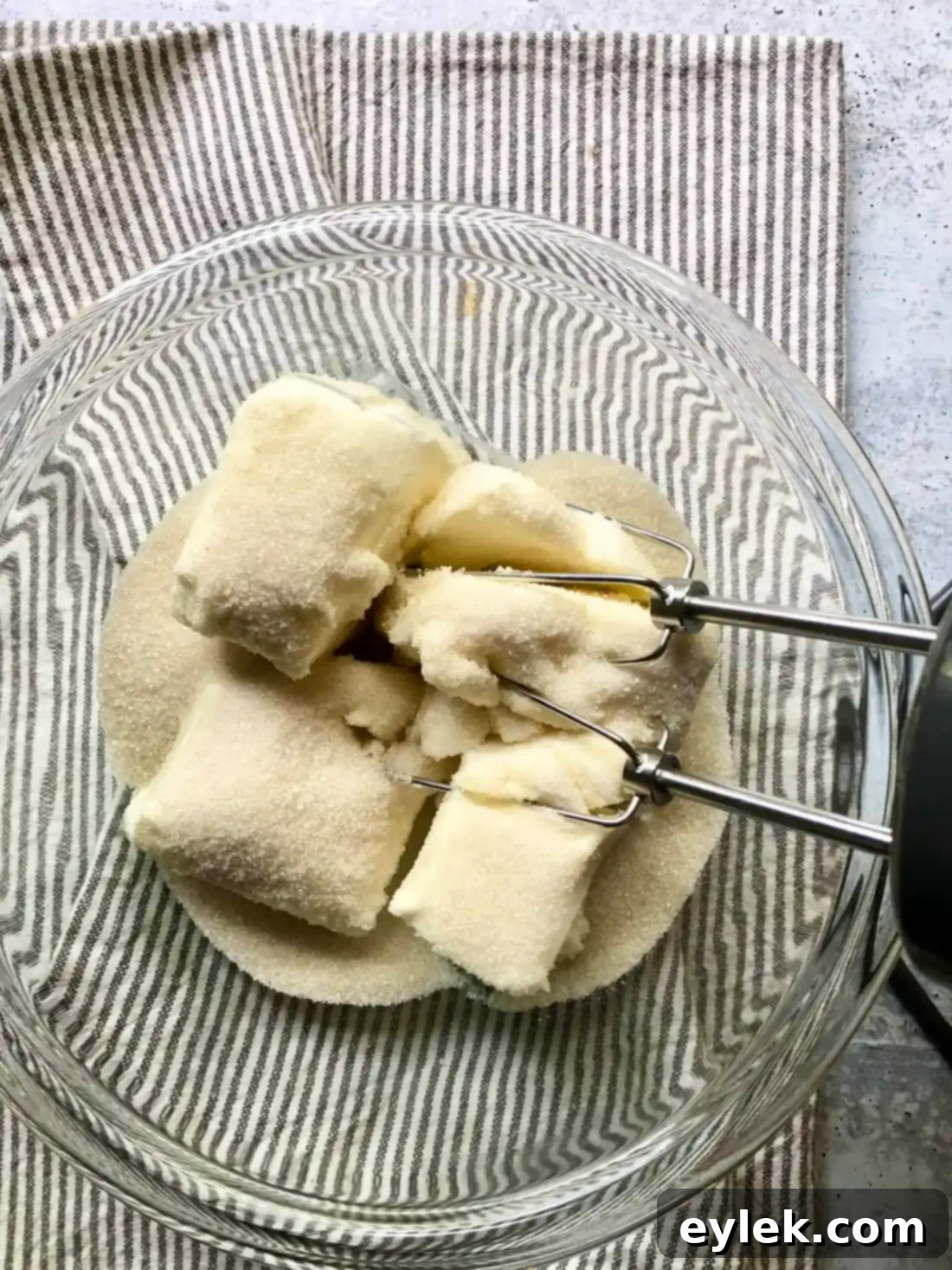 Creaming together cream cheese and sugar for the cheesecake batter.