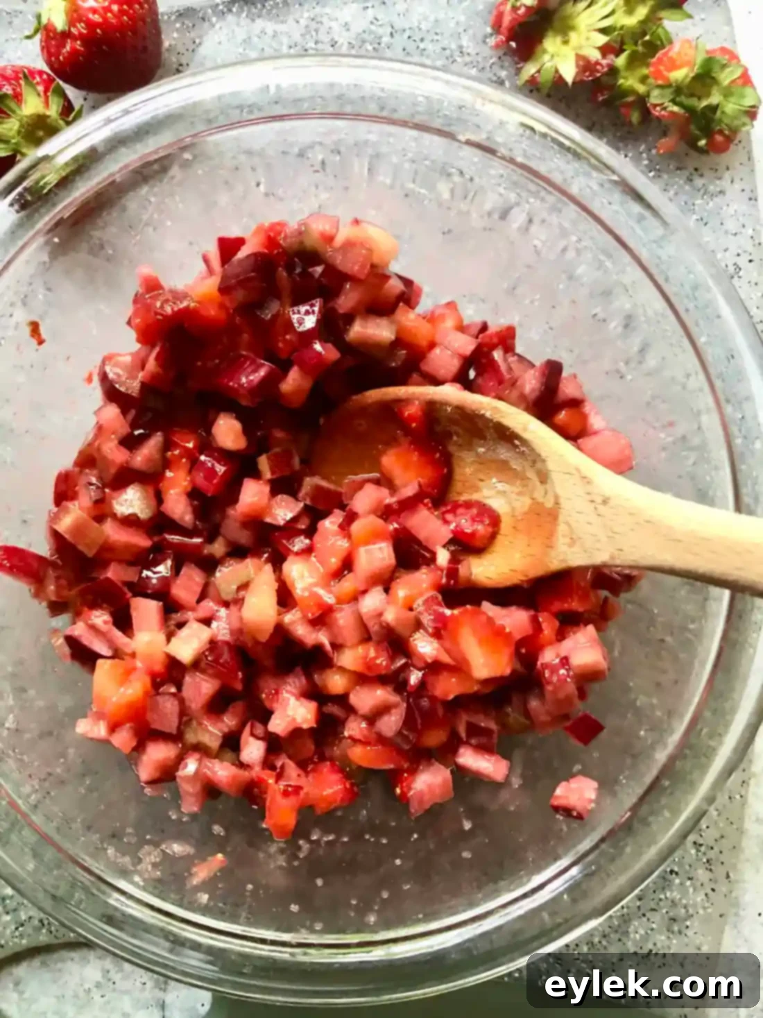 Sprinkling the remaining coconut oat crumble over the fruit layer.