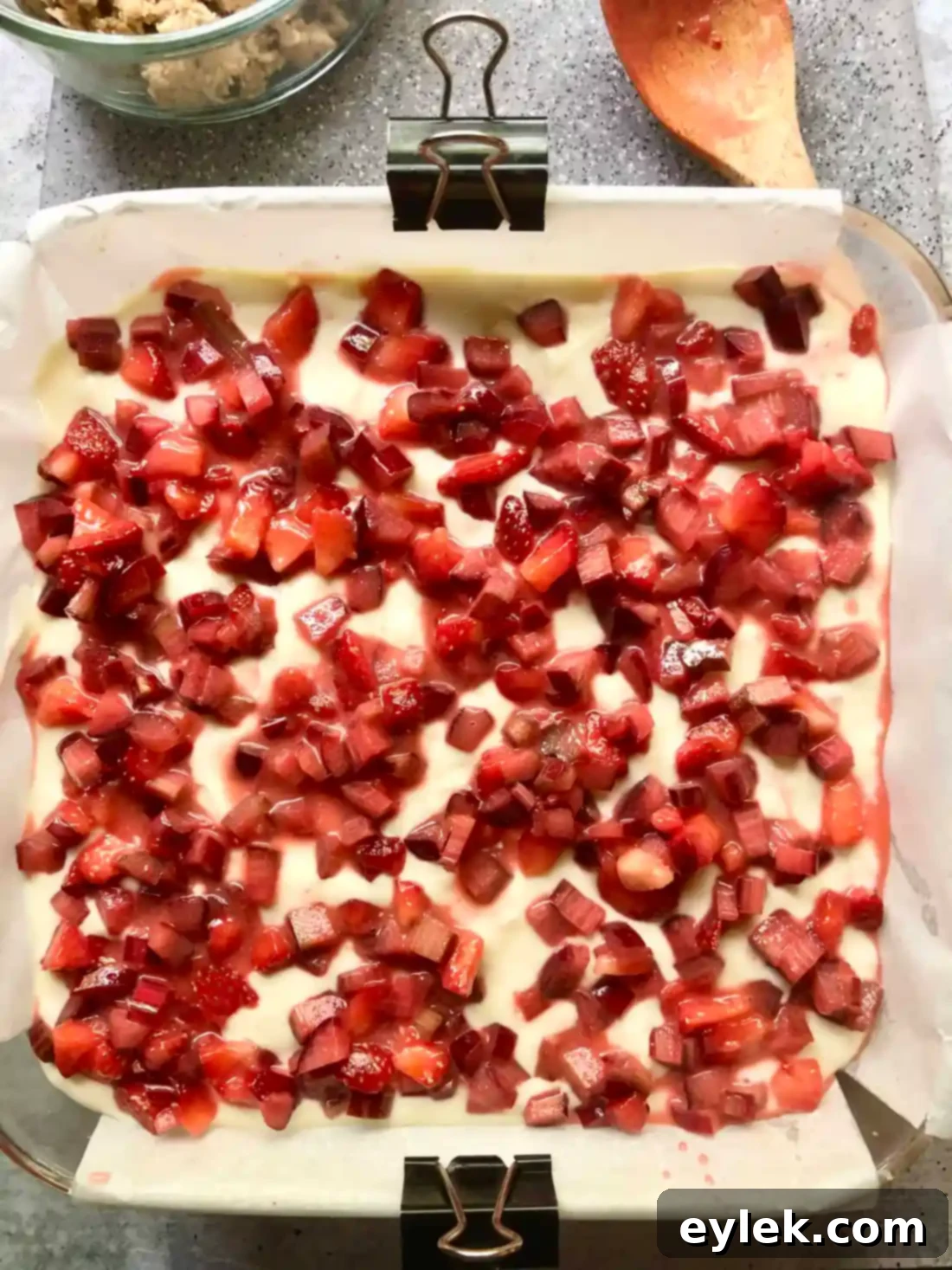 The strawberry rhubarb cheesecake squares, topped with crumble and additional fruit, ready for the final bake.