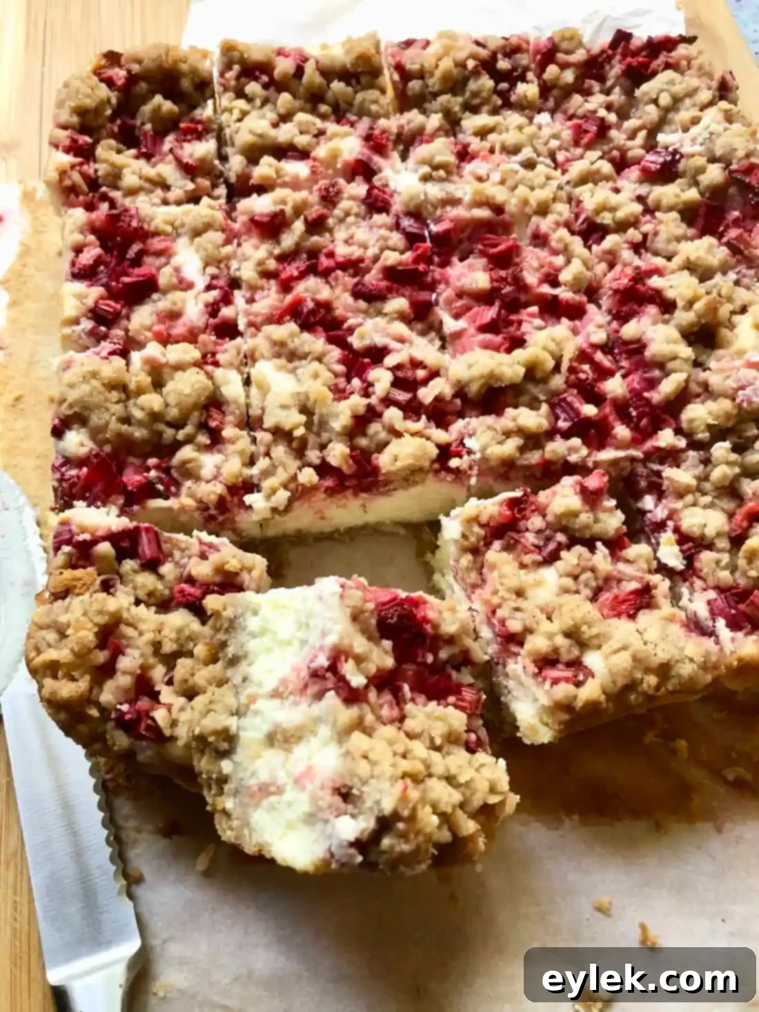 Cutting the chilled Strawberry Rhubarb Cheesecake Squares into individual portions.