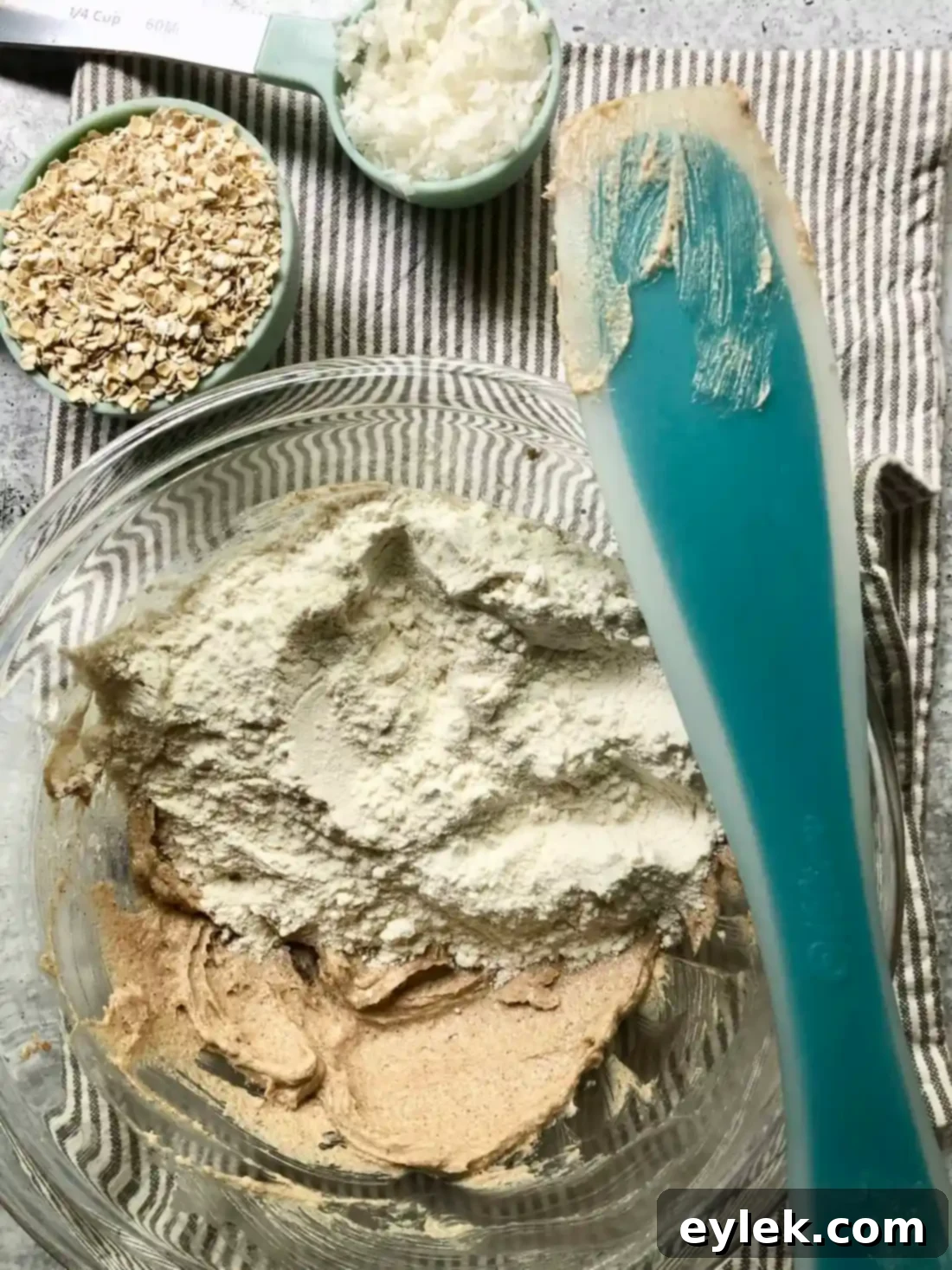 Pressing the coconut oat crumble into the baking pan for the crust.