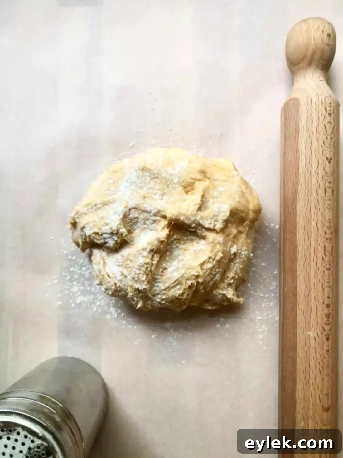 Rolling out pizza dough on parchment paper