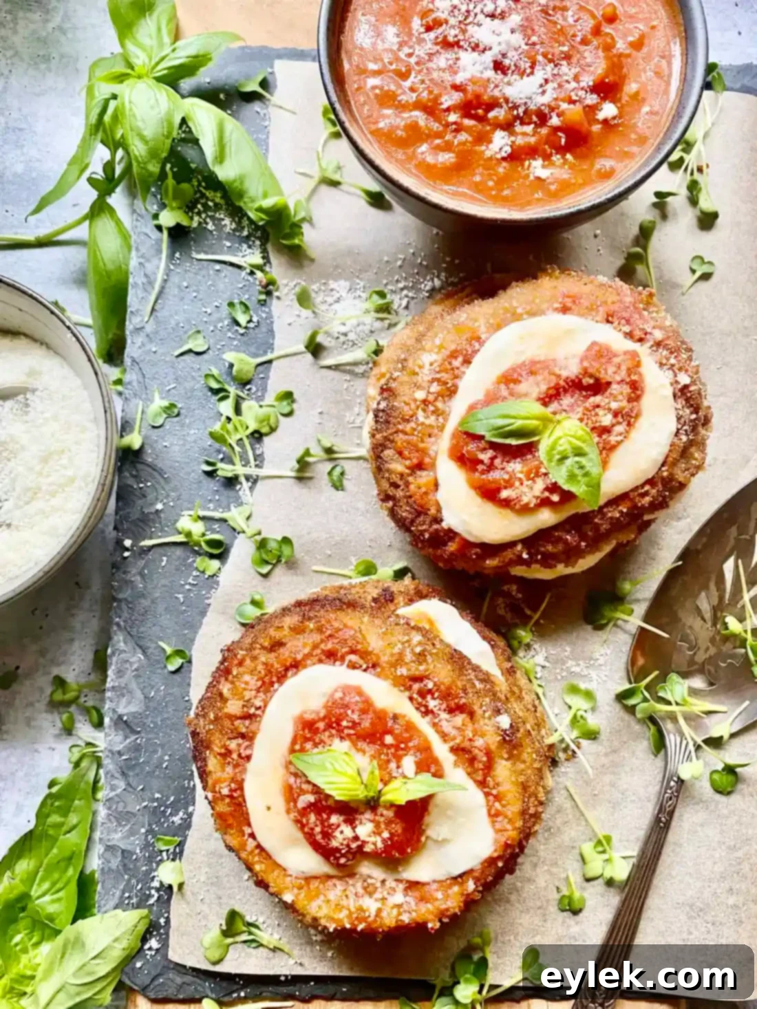 Three Fried Eggplant & Tomato Stacks on a serving plate.
