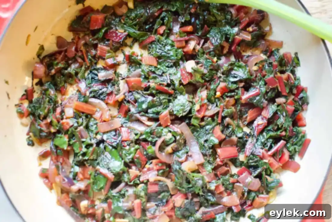 Sautéed Swiss chard with onion and garlic in a pan, ready for the next step