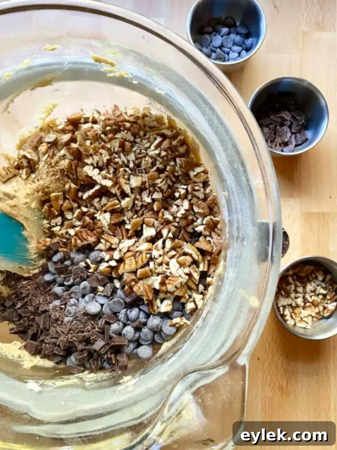 Folding chocolate and pecans into cookie dough