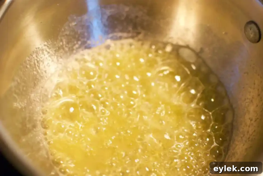 Hands stirring in different inclusions to separate bowls of muffin batter for variety.
