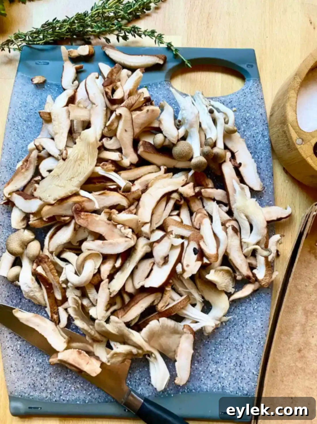 Wild mushrooms arranged in a single layer in a large skillet, starting to sear