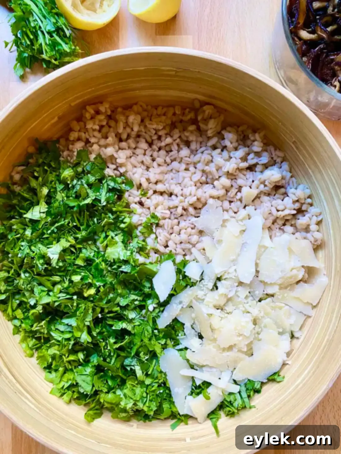 Mixing barley with herbs, lemon juice, Parmesan, and reserved shallot oil in a large bowl