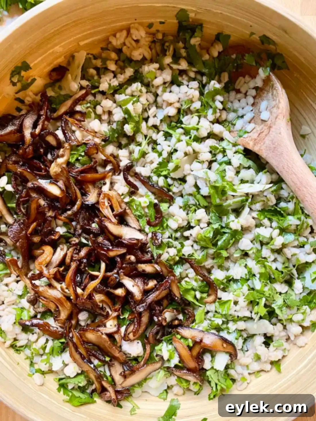 Adding buttery mushrooms to the barley and herb mixture