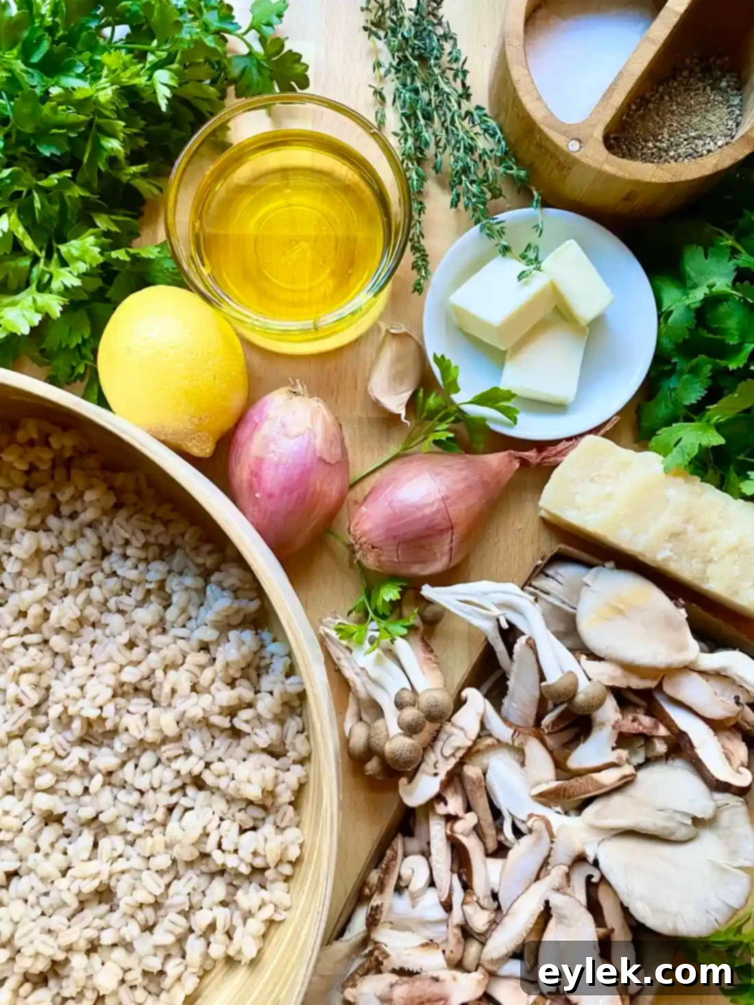 All ingredients laid out for Herby Barley Salad with Buttery Mushrooms, including fresh herbs, mushrooms, shallots, garlic, and cheese