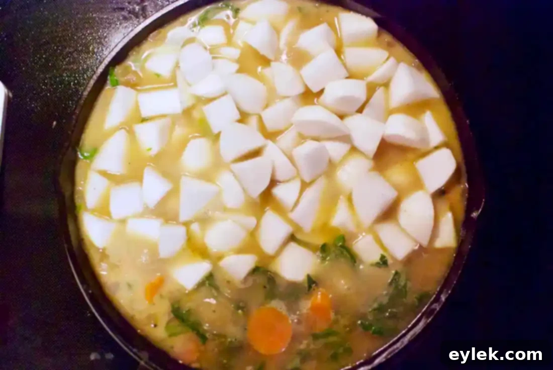 Sautéing onions and carrots in a skillet for pot pie