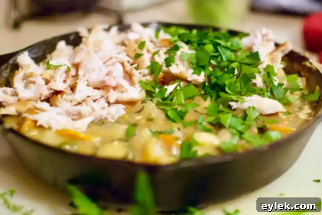 Skillet pot pie filling simmering with chicken and root vegetables