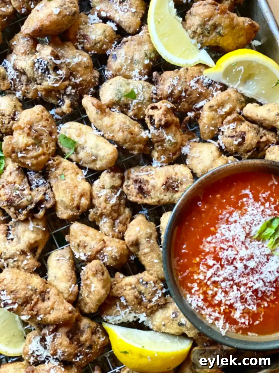 Platter of crispy fried artichoke hearts with lemon and marinara