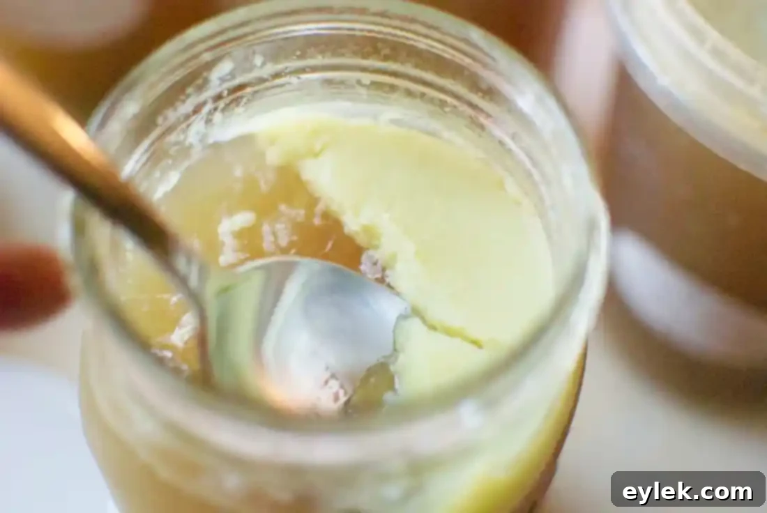 Skimming fat from chilled homemade chicken stock in a jar