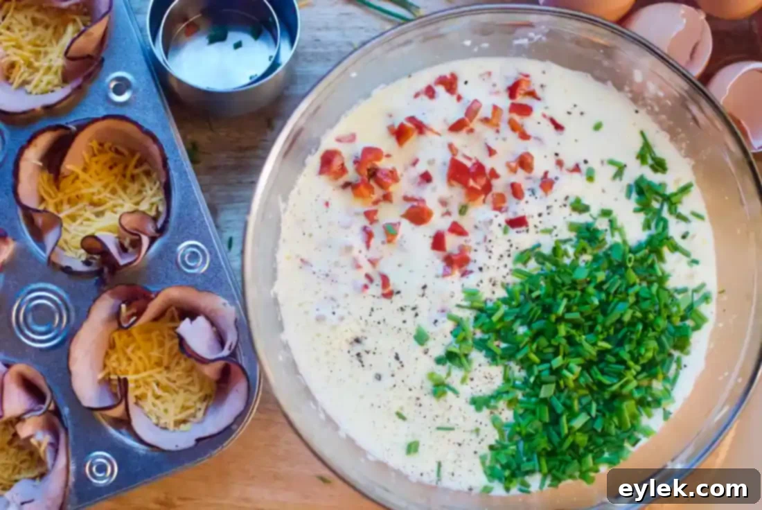 Egg mixture with roasted red peppers and chives in a bowl