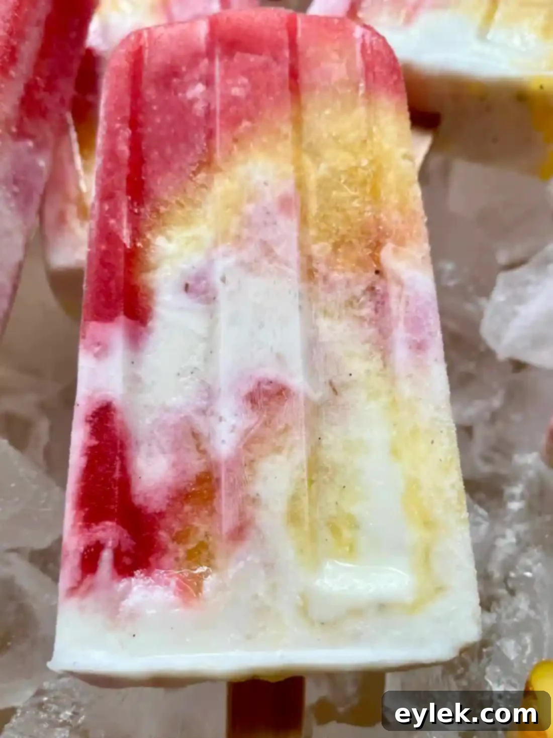 Frozen peach melba popsicles stored in a container