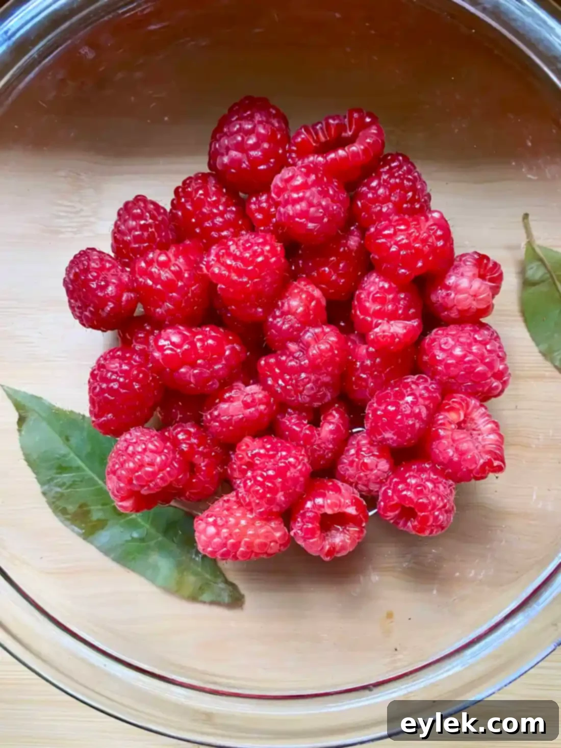 Raspberries being tossed with simple syrup for Melba sauce