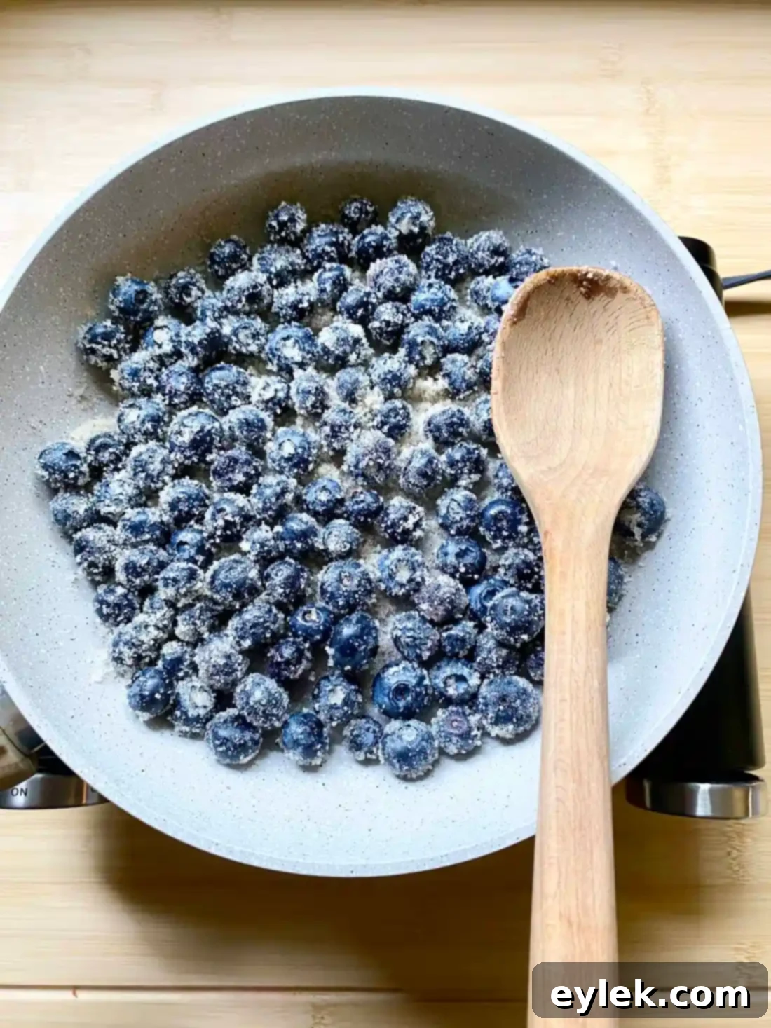 Blueberry sauce thickening in saucepan