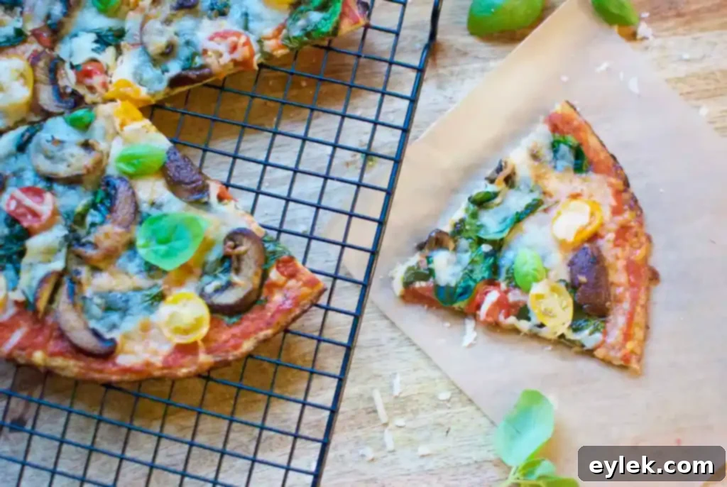 Two slices of the ultimate cauliflower crust pizza, showing the firm crust and fresh toppings.