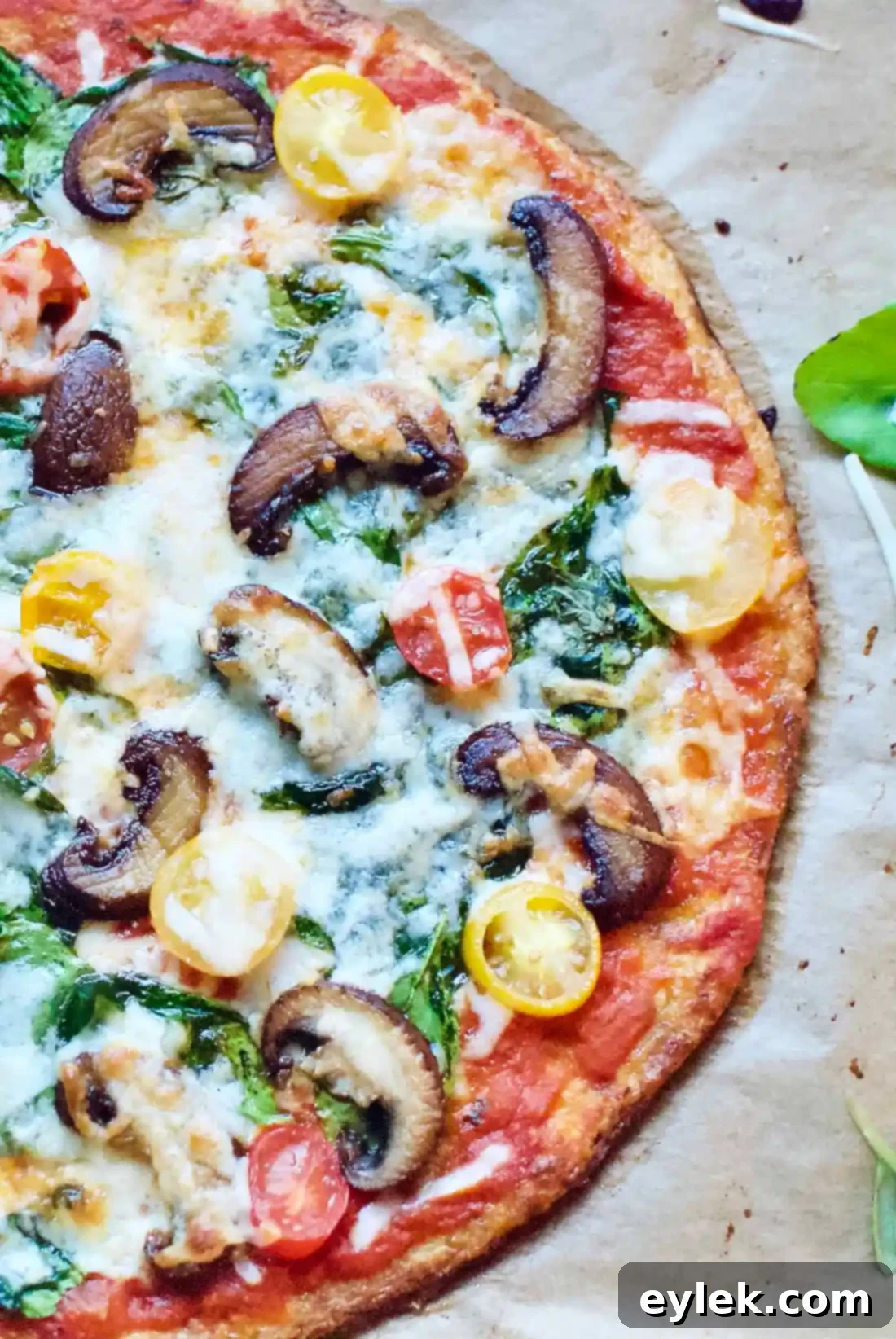 The ultimate cauliflower crust pizza, presented beautifully with vibrant, fresh toppings on a wooden board.