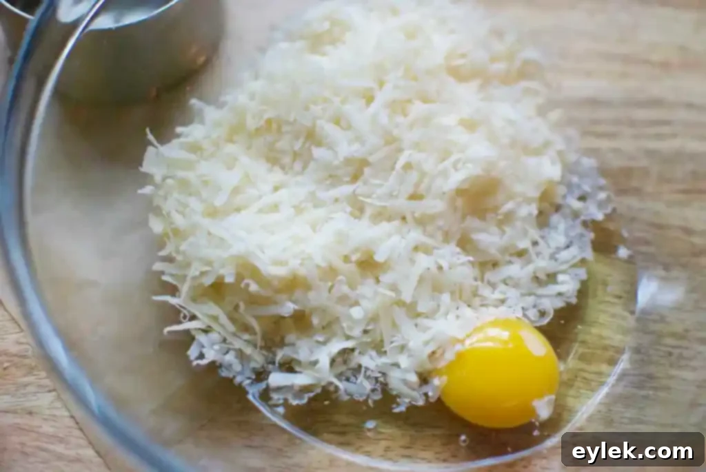 Grated cauliflower drying in a skillet, a crucial step for a crispy crust.