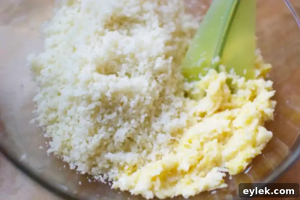 Beaten egg and grated Parmesan cheese, ready to be mixed with cauliflower for the pizza crust.