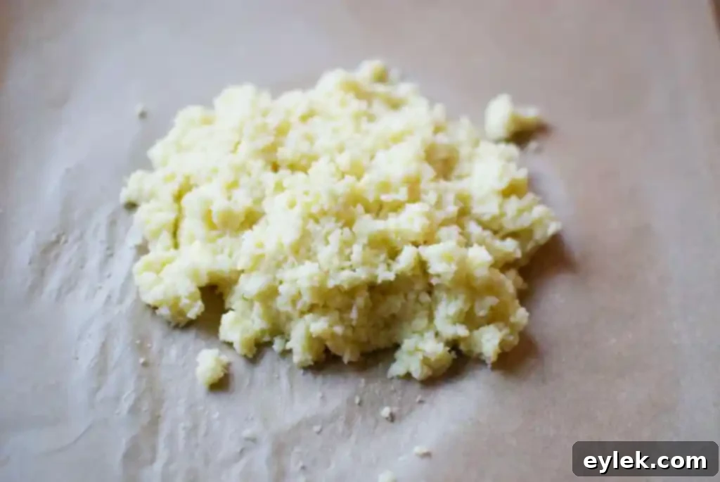 Cauliflower crust mixture formed into a ball in a bowl, ready for shaping.