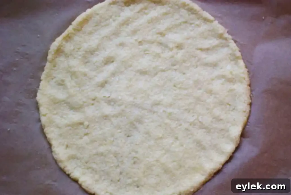 Parchment paper laid out on a baking sheet, preparing for the cauliflower pizza crust.
