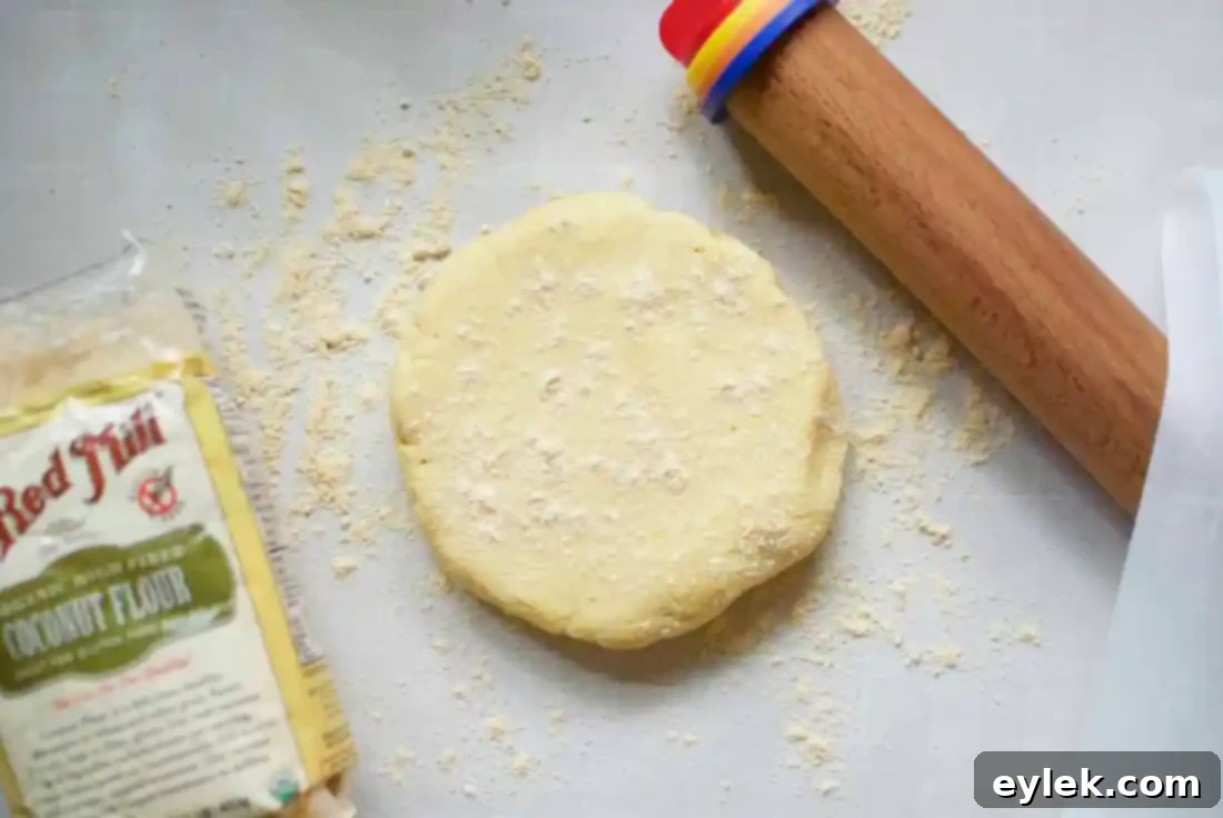 Rolling out low-carb empanada dough between parchment paper