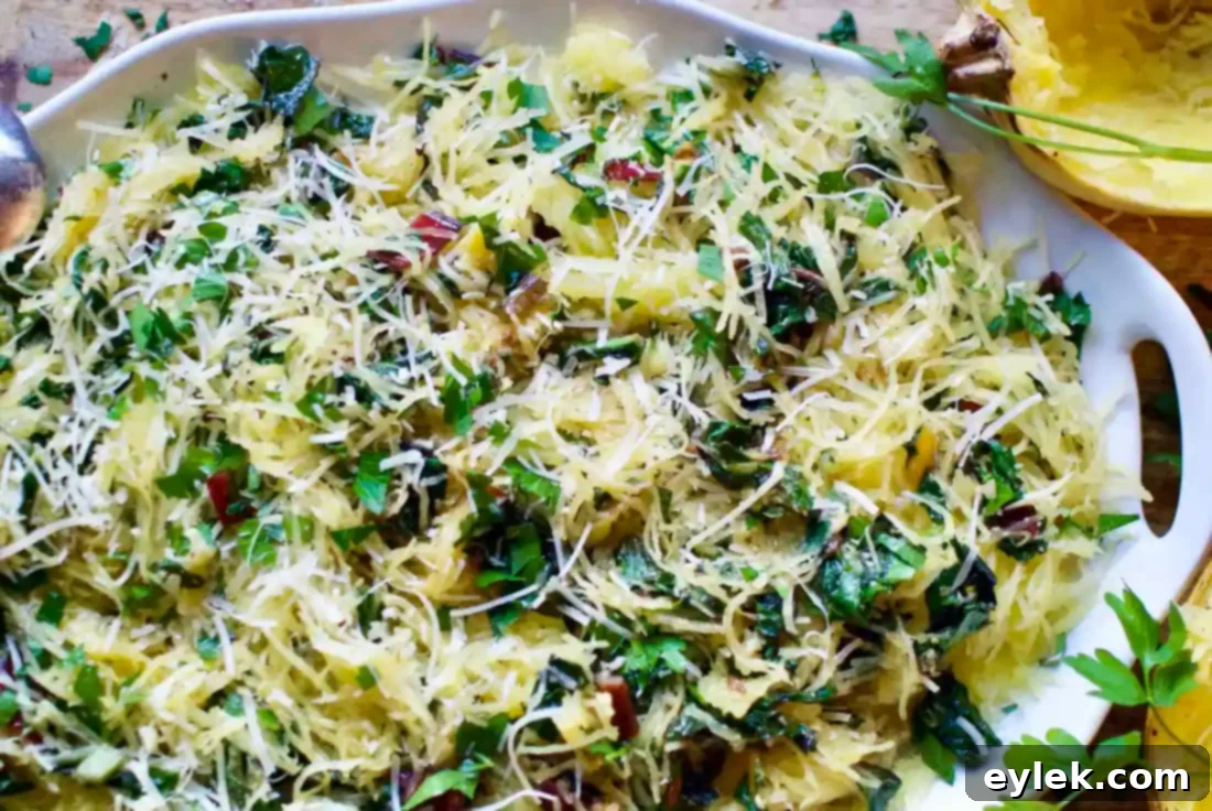 Served plate of Spaghetti Squash Aglio E Olio with Rainbow Chard, topped with fresh parsley and Parmesan.