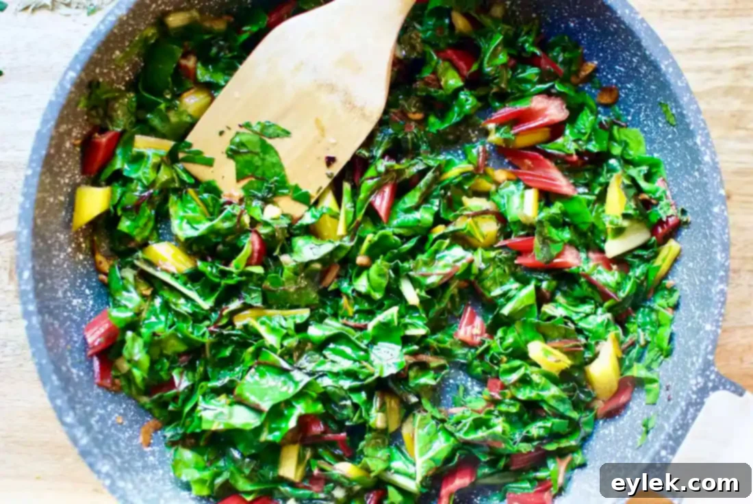 Adding rainbow chard to the Aglio E Olio sauce mixture.