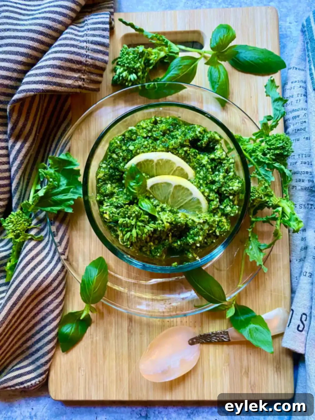 A generous serving of vibrant Broccoli Rabe & Lemon Pesto in a bowl with a spoon, ready to be eaten.