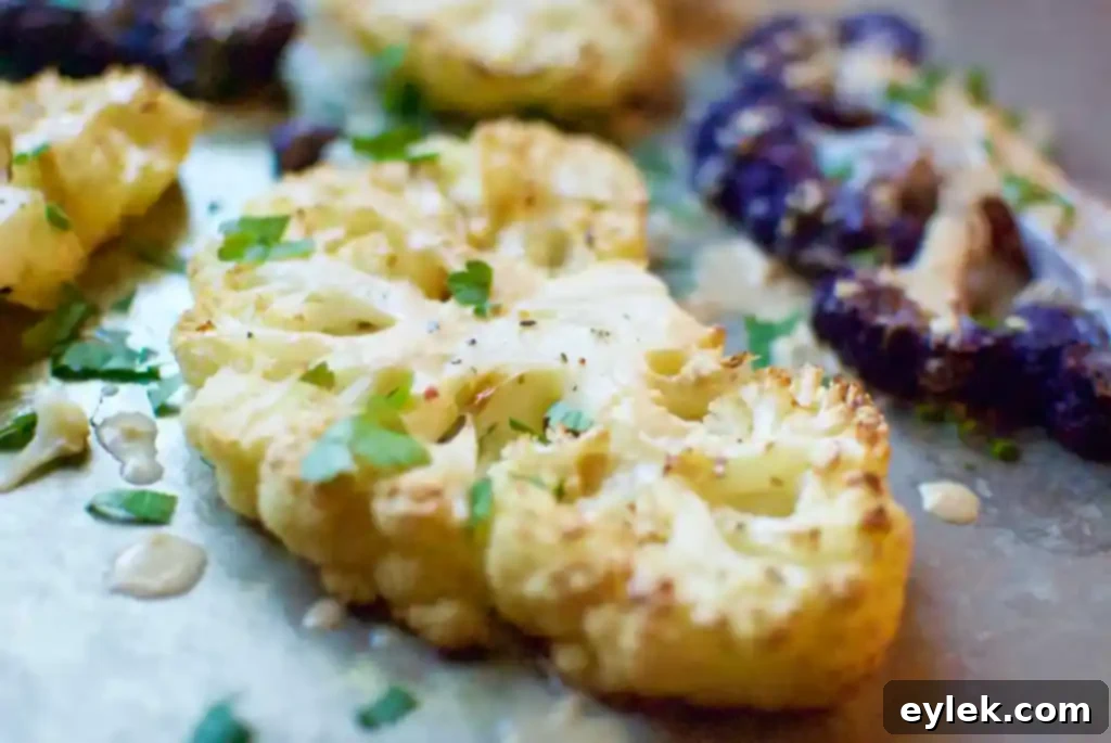 Finished Roasted Cauliflower Steaks with Thai Peanut Sauce garnished with parsley and lime