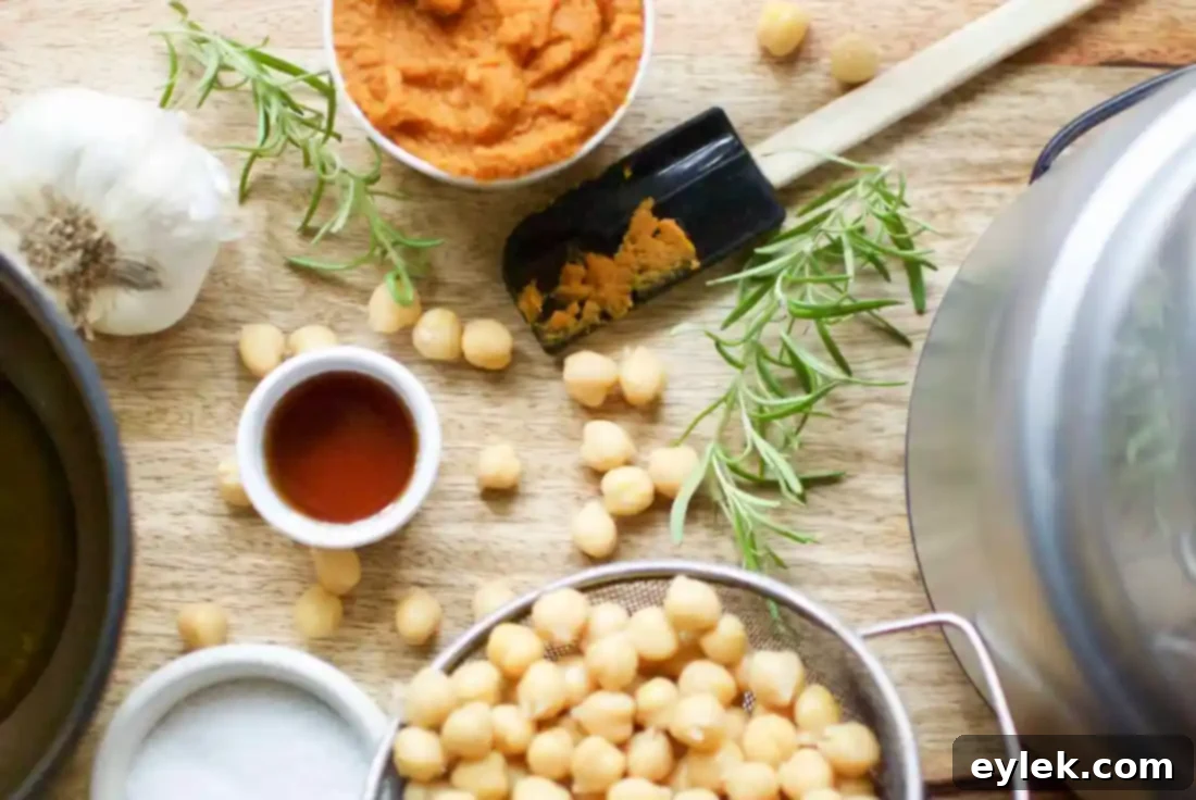 Creamy Pumpkin Hummus with Rosemary and Roasted Garlic in a bowl, garnished with fresh rosemary