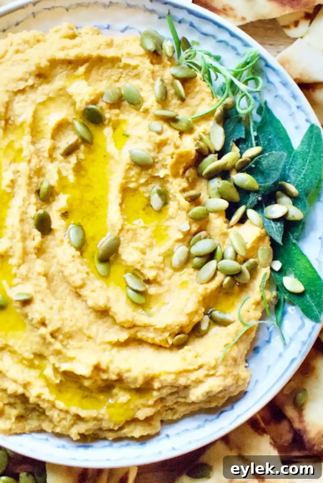 Overhead shot of Pumpkin Hummus with Rosemary & Roasted Garlic, garnished and ready to serve