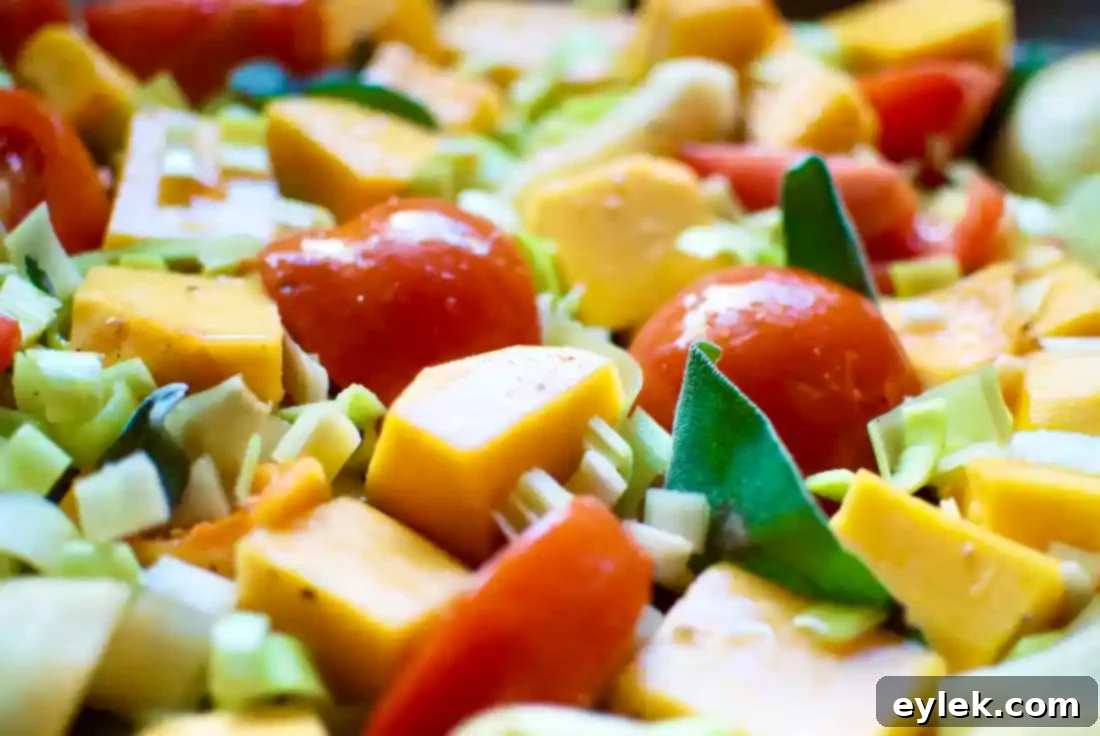 Butternut squash and pears roasting on a baking sheet with sage